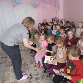 На фото - фахівці FSD роздають дітям роздатковий матеріал