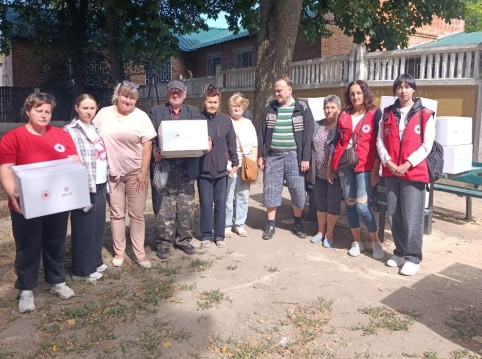 Фотографія представники Корюківської філії Чернігівської обласної організації Товариства Червоного Хреста в Мені допомагають жителям